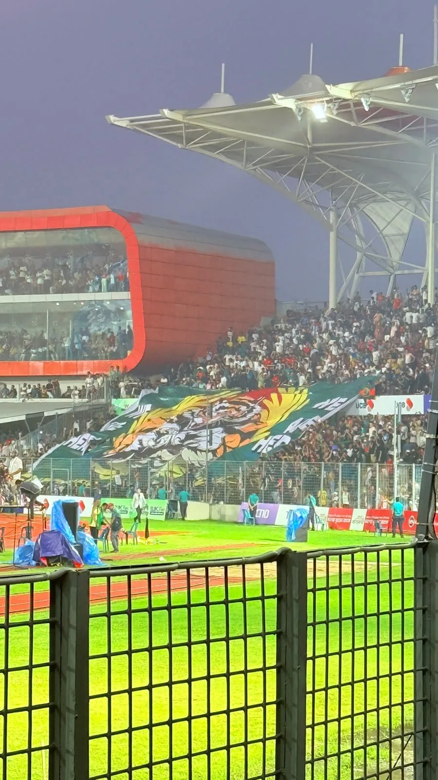A tiger tifo spread over the stand in the evening light.